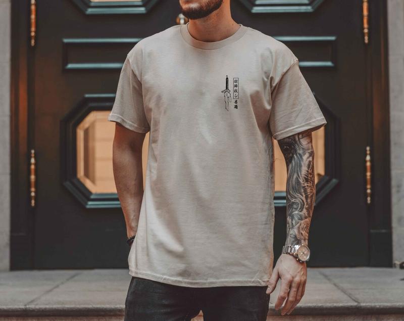 a man with a beard and tattoos standing in front of a door