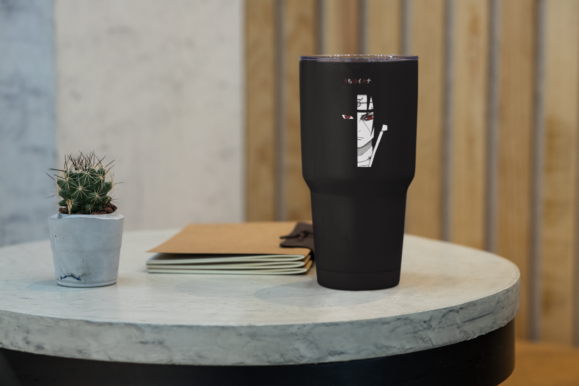 a black cup sitting on top of a table next to a plant