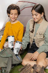 two young girls sitting on the ground holding coffee cups