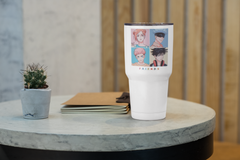 a white cup sitting on top of a table next to a potted plant