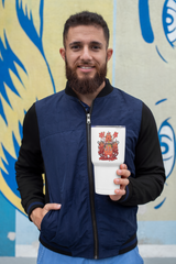 a man holding a cup in front of a painting