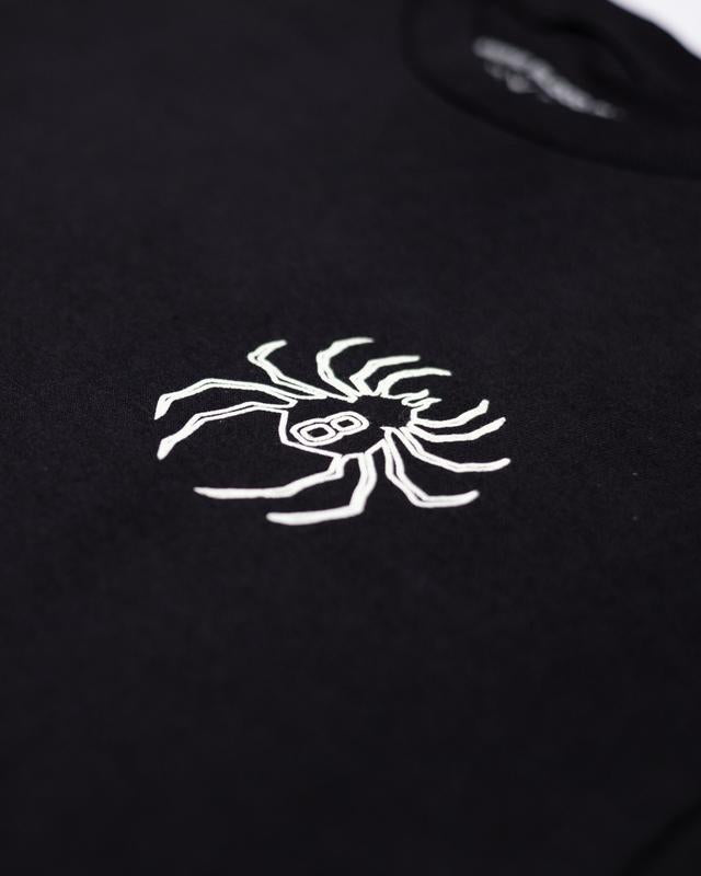 a black t - shirt with a white spider on it