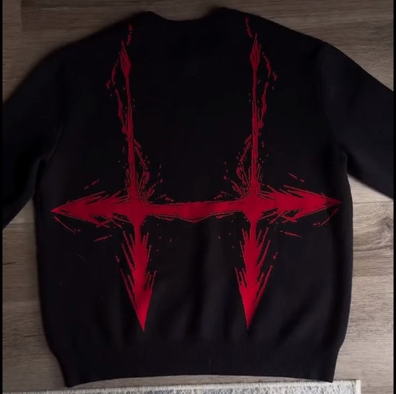 a black sweater with red paint splattered on it